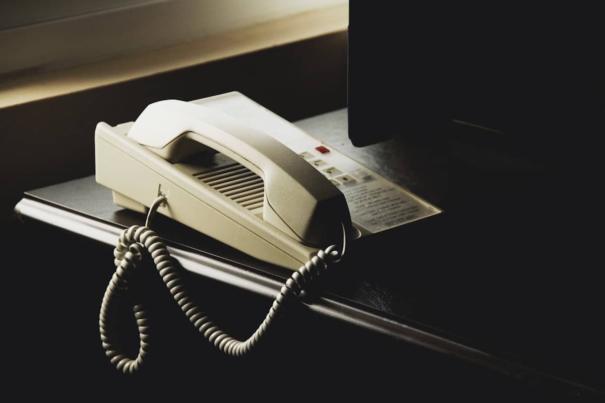An unattended desk phone in a dim office